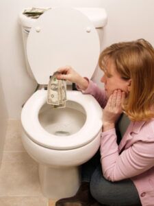 Woman flushing money down toilet