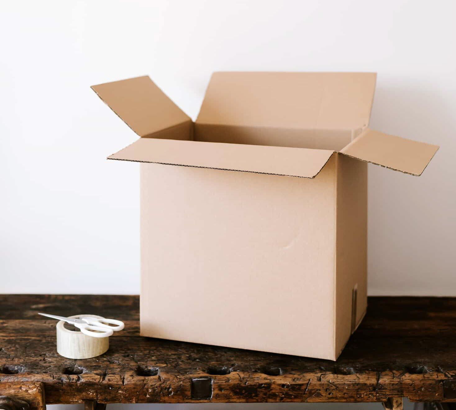 A box on a table with scissors and tape